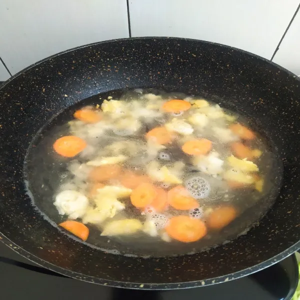 Masukan air kaldu udang lalu masykan wortel masak hingga air mendidih.