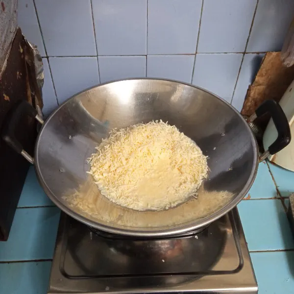 Dalam wajan masukkan keju parut dan susu cair. Masak dengan api kecil.
