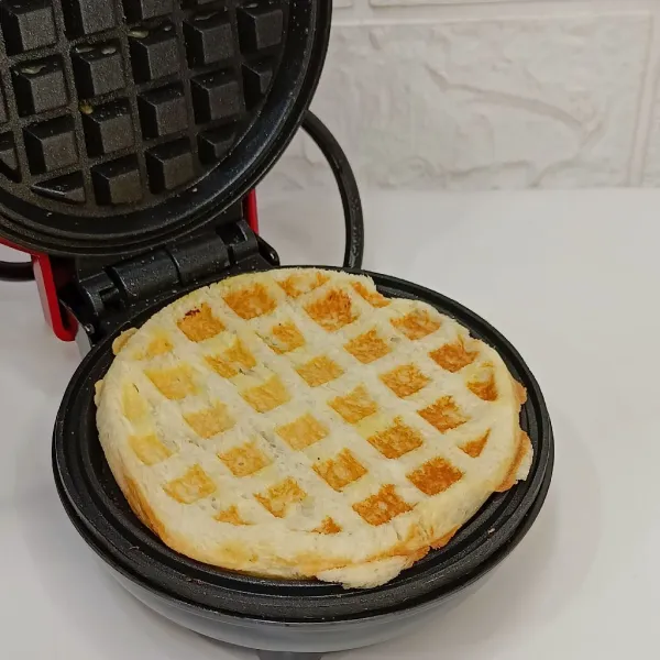 Masukkan roti ke waffle maker yang sudah dioles margarin.