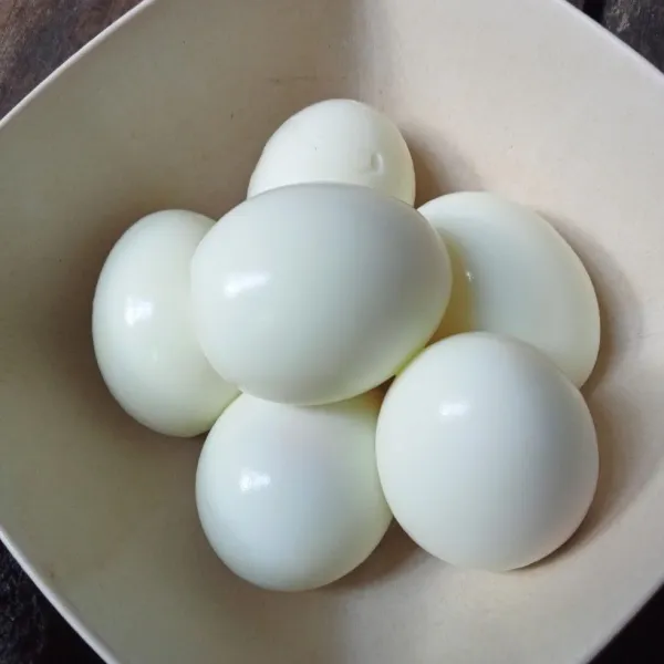 Rebus telur sampai matang, lalu kupas kulitnya.