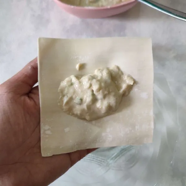 Ambil 1 lembar kulit pangsit, kemudian beri sedikit adonan tepung.