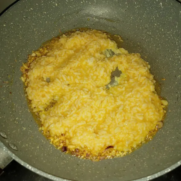 Masukkan nasi telur, aduk-aduk sampai terlihat nasi tidak basah oleh telur.
