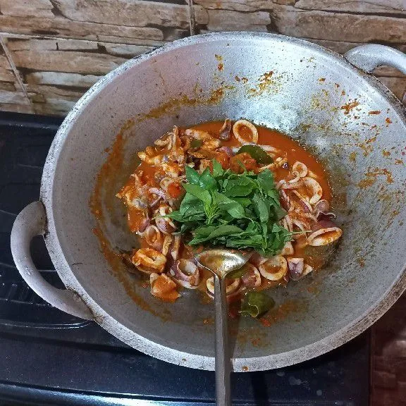 Masukkan daun kemangi, aduk rata. Matikan api.
