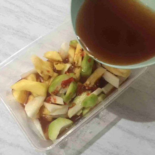 Setelah dingin, tuang kuah ke dalam wadah yang berisi buah-buahan.