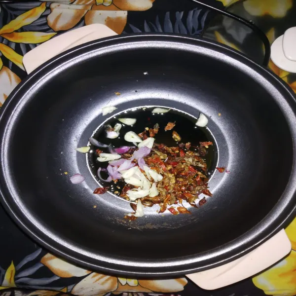 Panaskan minyak goreng kemudian tumis bawang putih, bawang merah dan rawit kering hingga layu.