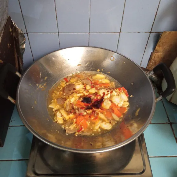 Masukkan wortel dan baby corn, masak hingga setengah matang, lalu tambahkan saus tiram, minyak wijen dan kecap ikan.