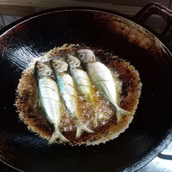 Goreng ikan dalam minyak panas sampai matang.