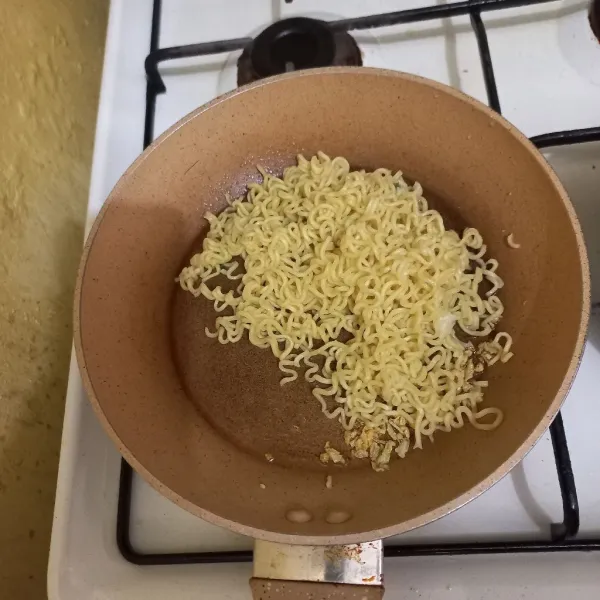 Masukkan mie rebus pada wajan yang berisi bawang putih goreng.