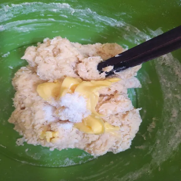 Tuang kocokan susu dan telur kedalam adonan kering lalu aduk dengan sumpit cukup sampai adonan tercampur rata. Lalu tambahkan margarin dan garam.