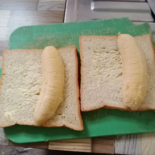 Taruh pisang di atas keju.