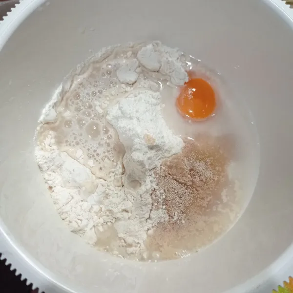 Masukkan tepung terigu, gula, ragi, air dan kuning telur ke dalam wadah, uleni setengah kalis.