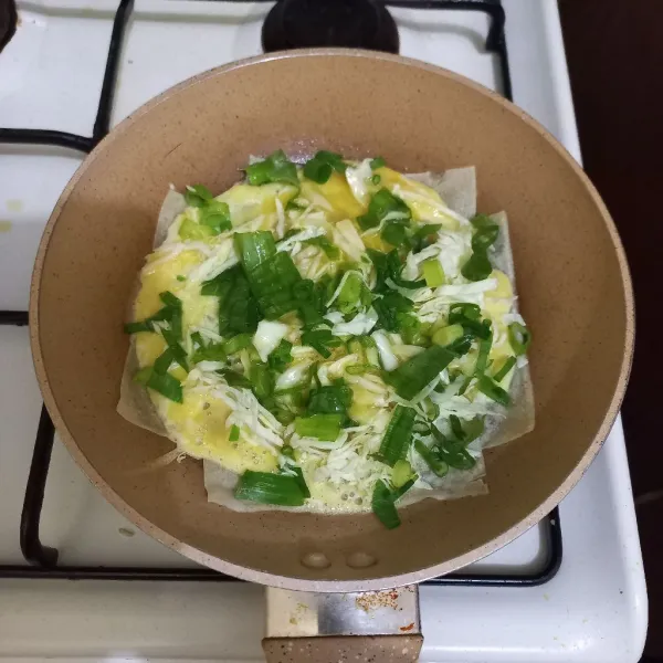 Masukan irisan bawang daun dan sisa kocokan telur.