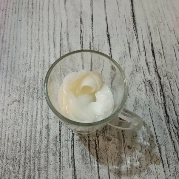 Masukkan es batu ke dalam gelas saji, lalu tambahkan jelly kelapa muda.
