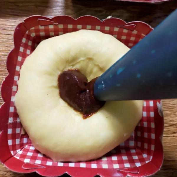 Letakkan pada loyang yang telah diolesi margarin atau pada paper  cupcake. Tekan bagian tengah roti dengan jari hingga membentuk cekungan. Isi dengan selai kopi. Diamkan selama 30 menit.