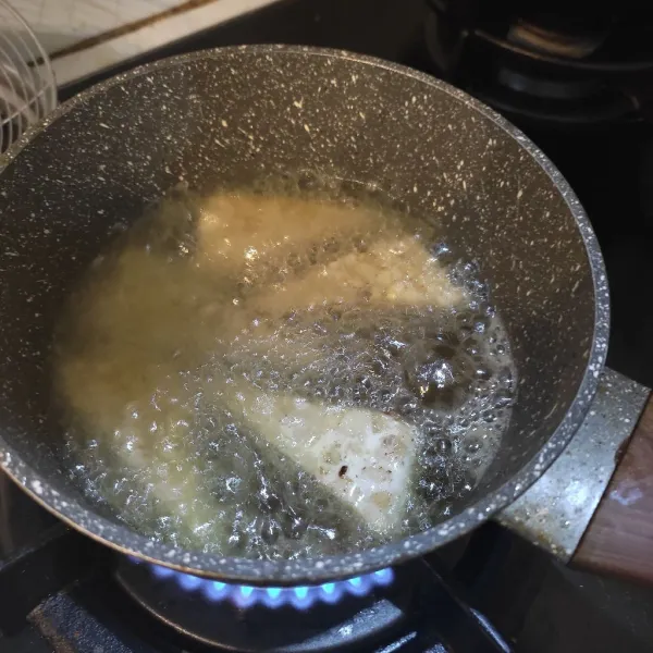 Goreng tempe dalam minyak panas hingga matang berwarna kuning kecoklatan.
