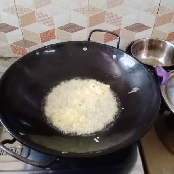 Masukkan minyak yang banyak dalam wajan. Panaskan minyak. Setelah panas, tuang 1/2 sendok sayur adonan telur ke wajan. Ambil tusuk sate tadi.