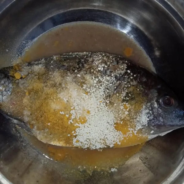 Masukkan bumbu kedalam wadah berisi ikan tambakan kunyit bubuk, garam dan kaldu jamur.