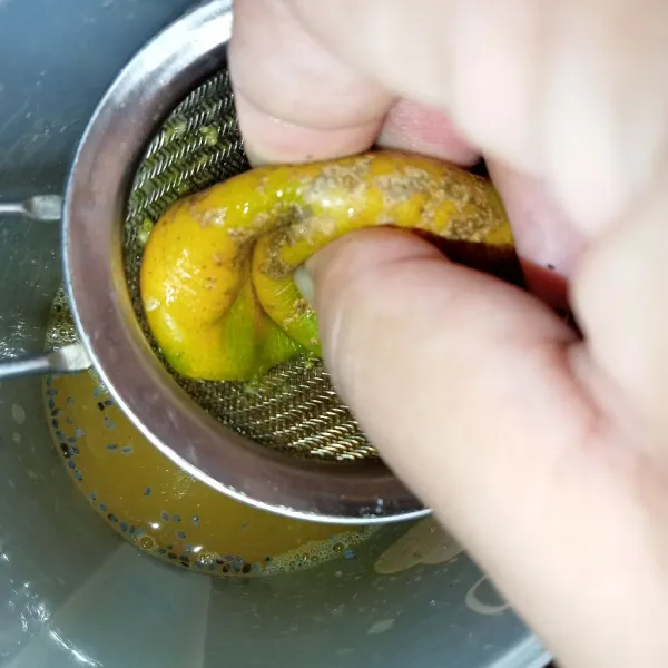 Lalu peras jeruk menggunakan saringan (tips memeras jeruk, jika tidak ada alat pemeras jeruk).