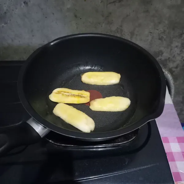 Goreng 2 buah pisang dengan margarin untuk dijadikan topping.