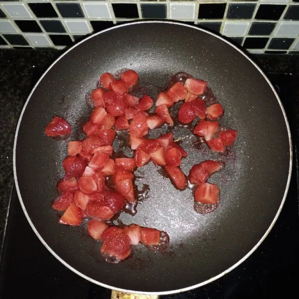 Masak strawberry dengan api kecil hingga meleleh. Pipihkan menggunakan spatula.