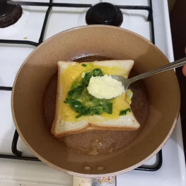 Tuang kocokan telur pada bulatan roti, tambahkan keju parmesan di atasnya, panggang hingga kedua sisi kecokelatan dan telur matang