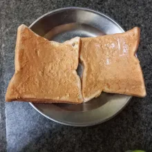 Olesi permukaan roti tawar dengan selai kacang, ratakan