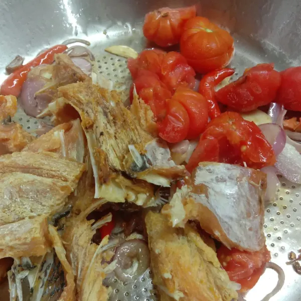 Masukkan ikan asin yang telah digoreng dan potongan tomat, aduk rata