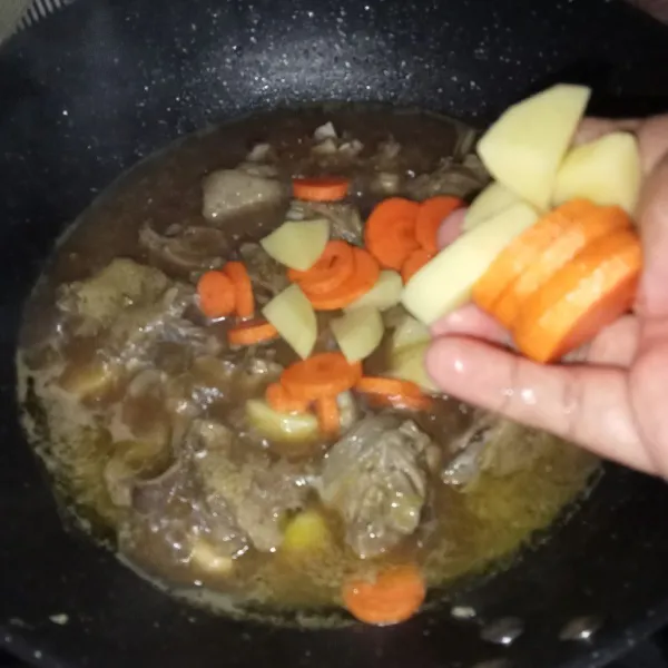 Masukkan kentang dan wortel, masak sampai matang dan kuah menyusut.