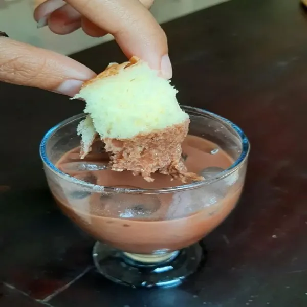 Hidangkan bersama roti tawar. Cara menikmati es coklat ini dengan cara mencelup roti tawar ke dalam es. Menyruput es sambil menikmati cocolan roti tawar. Nikmat 👍