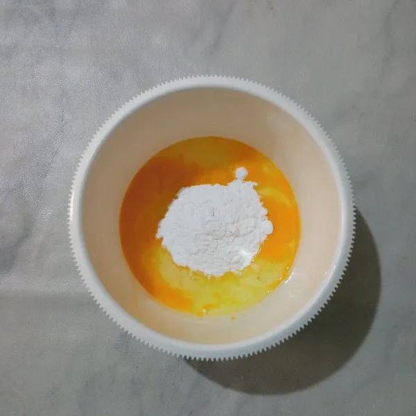 Dalam wadah, masukkan telur dan gula halus.