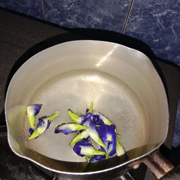 Didihkan air dalam panci. Lalu masukkan bunga telang.