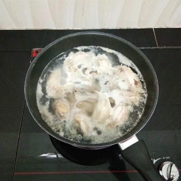Lalu rebus sayap ayam dengan secukupnya air hingga mendidih, lalu tiriskan ayam dan buang air rebusannya. Sisihkan.