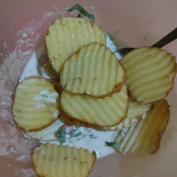 Masukkan kentang ke dalam adonan tepung, aduk hingga kentang terlumur adonan.