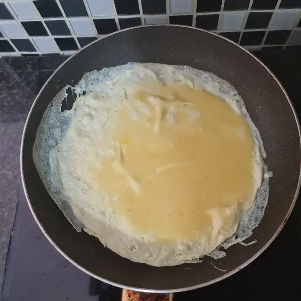 Dadar telur di atas frying pan dengan olesan margarin.