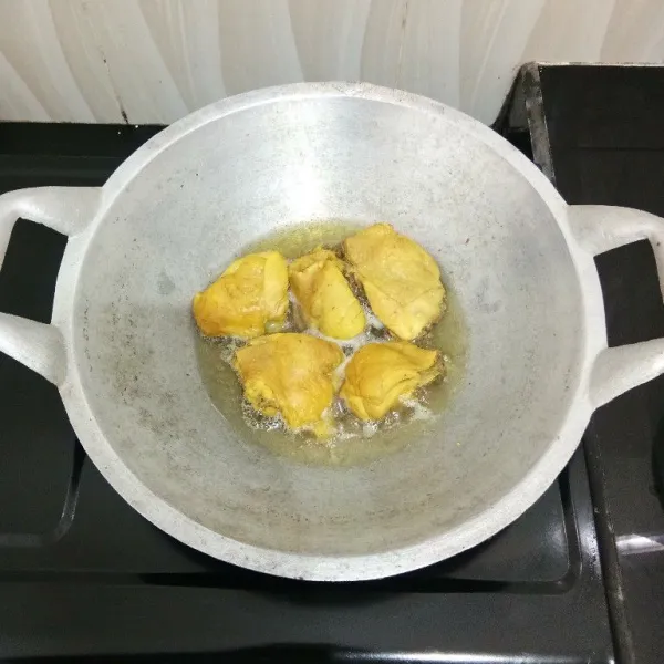 Kemudian goreng ayam dalam minyak panas hingga matang kecokelatan, lalu angkat dan tiriskan.
