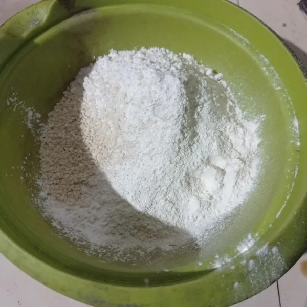 Masukkan tepung beras, tepung terigu, gula pasir, kelapa parut, wijen dan baking powder ke dalam wadah.