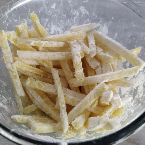 Masukkan tepung maizena, aduk rata hingga semua kentang terlapisi.
