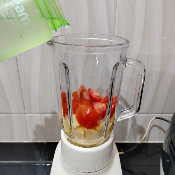 Masukkan tomat dan apel ke dalam blender. Lalu masukkan air.