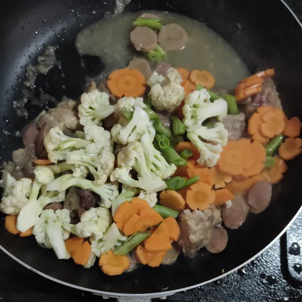 Masukkan sayur kecuali sawi, tambahkan sedikit air lalu bumbui dengan lada bubuk, gula, garam serta minyak wijen.