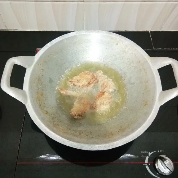Lalu goreng sayap ayam dalam minyak panas hingga matang. Kemudian angkat dan tiriskan.