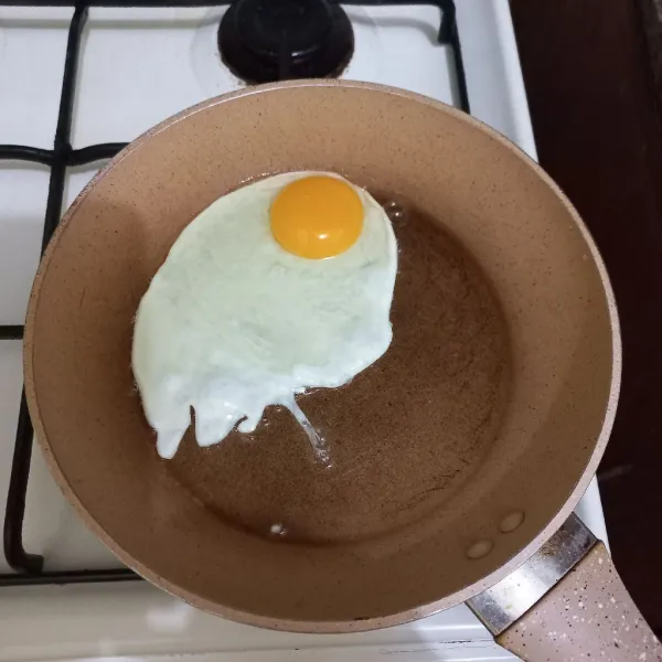 Ceplok telur ayam dan tambahkan garam, kemudian masak hingga kematangan yang diinginkan, lalu sisihkan.