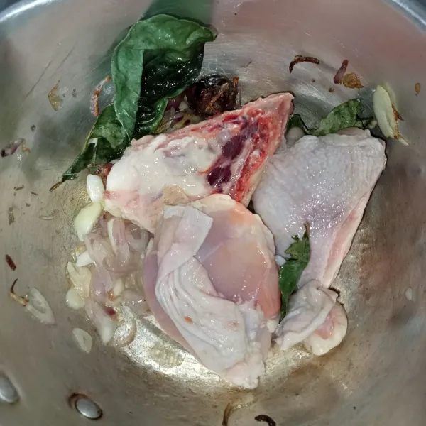 Tumis bumbu iris, lengkuas, dan daun salam dengan minyak hingga harum, lalu masukkan ayam dan aduk rata. Tunggu sampai ayam berubah warna.