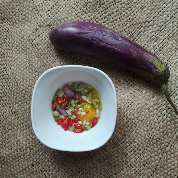 Dalam wadah campur telur, bawang putih, irisan bawang merah, irisan daun bawang, irisan cabe.