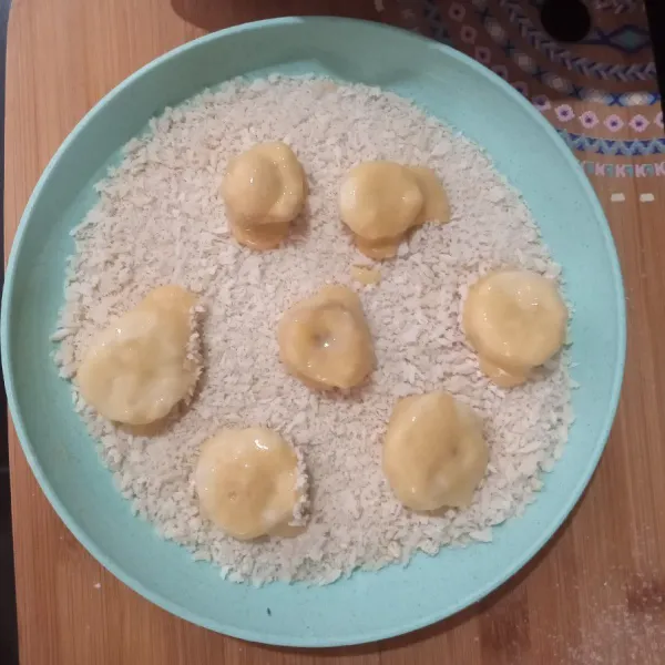 Lalu gulirkan pisang ke tepung roti.