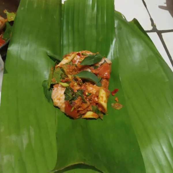 Siapkan daun pisang. Masukkan ayam, bungkus dan sematkan dengan tusuk gigi.