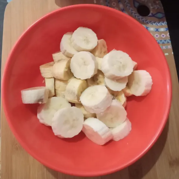 Kupas pisang lalu potong bulat dan masukkan ke dalam mangkuk.