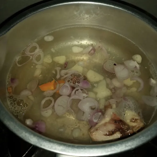 Rebus air sampai mendidih. Masukkan bawang putih, bawang merah, asam jawa, kunyit dan lengkuas. Rebus selama 5 menit dengan api sedang.