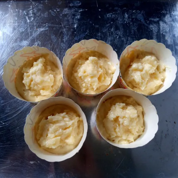 Siapkan papercup, masukkan 1 sdm adonan. Tambahkan 1 sdt cheese filling. Tambahkan adonan lagi sampai 3/4 tinggi cetakan.