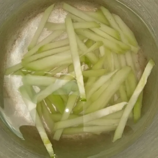 Potong memanjang sayur jepang/labu siam dan rendam air garam untuk mengurangi getah jepang. Cuci bersih.