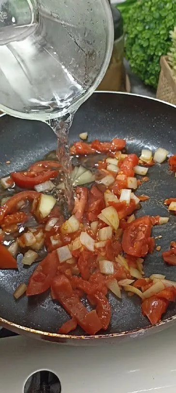 Tumis cincangan tomat hingga lembut, masukkan irisan tomat dan bawang bombay tumis hingga layu, tambahkan air, masak hingga mendidih.